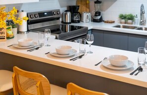 A modern kitchen with a central island, equipped with a coffee maker, toaster, and blender.