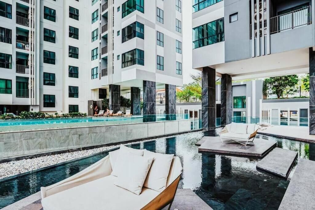 Ett modernt hotell med en poolanläggning på taket, inklusive solstolar och en swimmingpool.