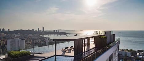 Une piscine sur le toit offrant une vue sur la ville et la mer.
