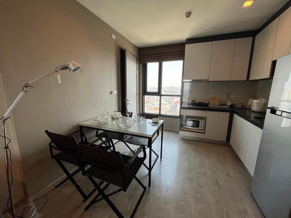 A modern kitchen with a dining area, a large window, and a view of the city.