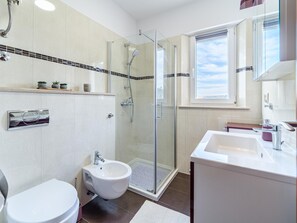 A modern bathroom with a glass-enclosed shower, a bidet, a toilet, and a vanity with a mirror. - Spacious Mediterranean 3-bedroom Apartment in Sutivan (Sutivan)