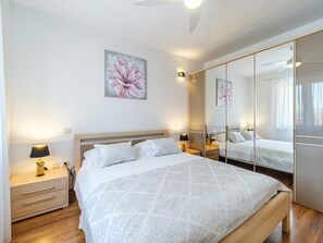 A bedroom with a bed, bedside tables, a lamp, a mirror, and a floral painting on the wall. - Spacious Mediterranean 3-bedroom Apartment in Sutivan (Sutivan)