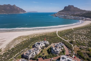 A coastal residential area with houses, a beach, and a marina. - PINGU Beachhouse | Beachfront Villa with Hot Tub, Ocean Views & Beach Access (Cape Town)