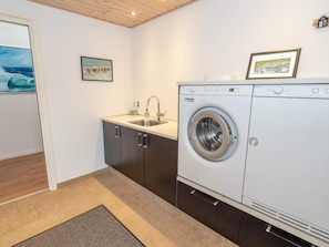 A laundry room with a washing machine, a sink, and cabinets. - 4 Star Holiday Home in Vestervig (Vestervig)
