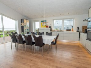 A modern kitchen with a dining area, large windows, and a view of the outdoors. - 4 Star Holiday Home in Vestervig (Vestervig)
