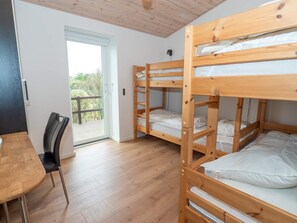 A room with a bunk bed, a desk, and a chair. There is a window with a view of trees. - 4 Star Holiday Home in Vestervig (Vestervig)