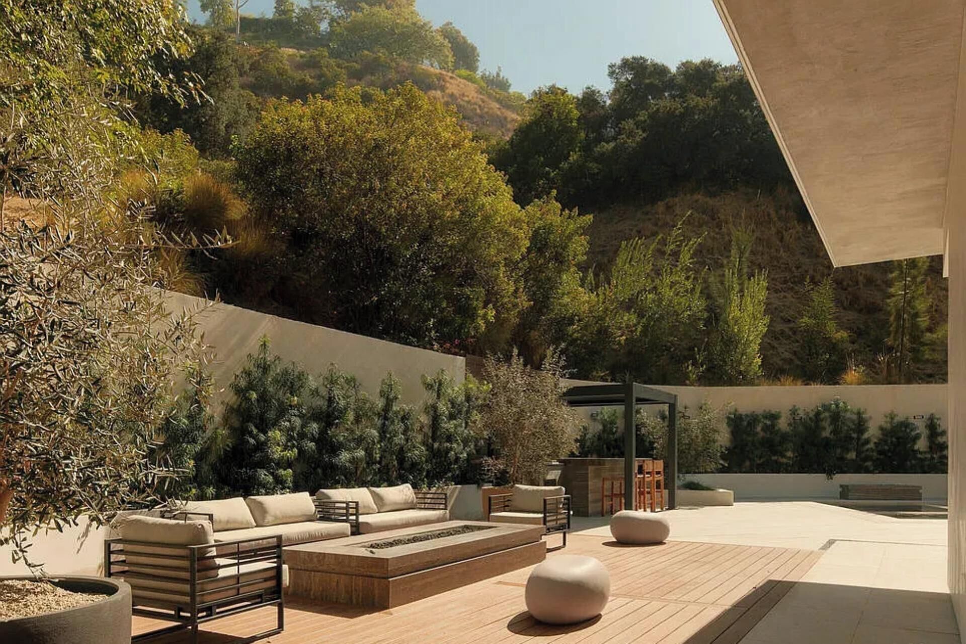An outdoor seating area with a sofa, chairs, and a fire feature.