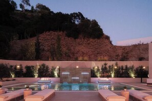 A swimming pool with lounge chairs and a waterfall feature. - Crown Ridge Estate - Exclusive Hollywood Hills Retreat | Resort-Style Living (Hollywood Hills)