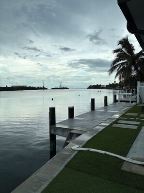 A waterfront walkway with a palm tree, a bridge, and a distant island. - SEASIDE SOIREE ~ NEW LISTING! Key Haven 4 BR/3 Ba Waterfront Home! (Key West)