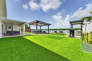 Eine gepflegte Terrasse mit Billardtisch, Sitzgelegenheiten im Freien und Grillplatz.