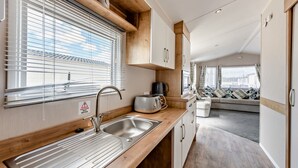 Eine Küche mit Spüle, Toaster und einem Fenster mit Jalousien.
