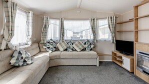 Ein gemütliches Wohnzimmer mit einer Couch, einem Flachbildfernseher und einem Kamin.