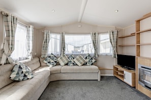 A cozy living room with a sofa, a flat-screen TV, and a fireplace. - Host Stay - Meadow View (Winchelsea)