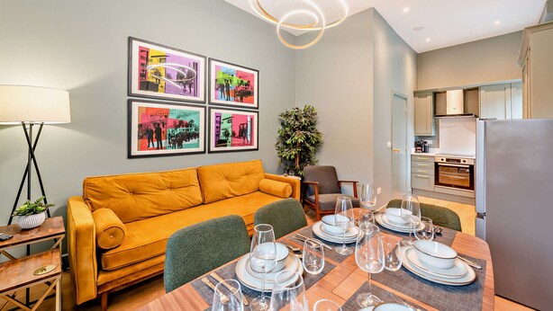 A modern living room with a sofa, dining table set for four, and a kitchen area with appliances. - Host Stay - The Georgian Quarter at Catharine I (Liverpool)