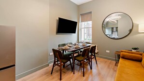 A dining area with a table set for four, a television mounted on the wall, and a large mirror. - Host Stay - The Georgian Quarter at Catharine I (Liverpool)