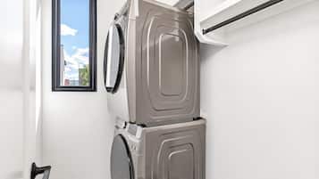 A laundry room with a washing machine and dryer stacked on top of each other.