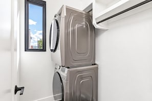 Un cuarto de lavado con lavadora y secadora apiladas.