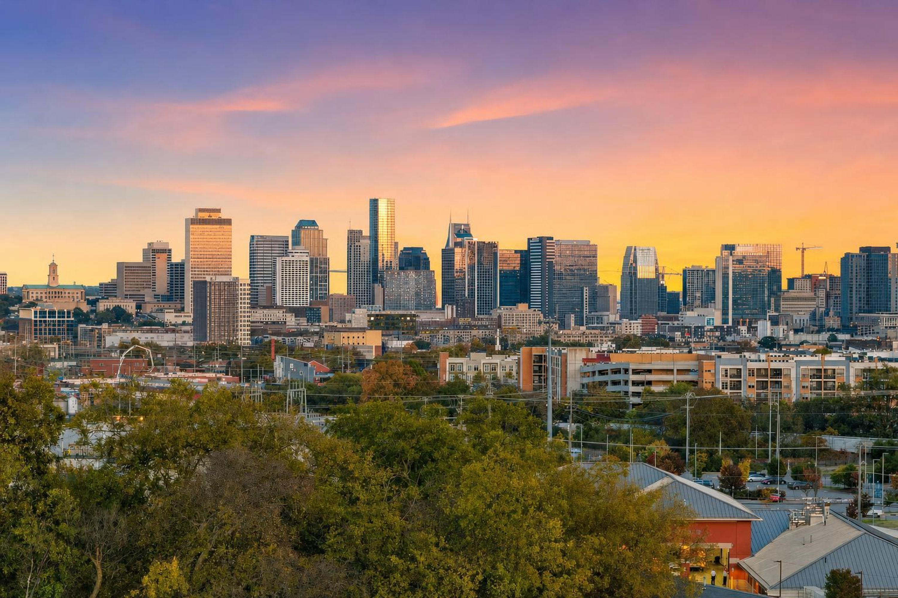 A city skyline with modern buildings, a mix of high-rise and mid-rise structures, and a clear sky.
