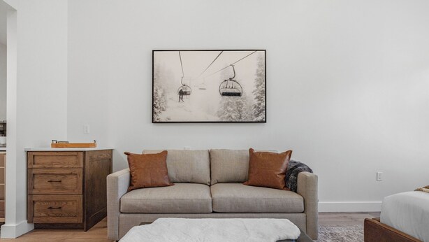 A modern living room with a sofa, a coffee table, a wooden cabinet, and a framed picture on the wall. - Luxury Penthouse Studio | Ski-In/Ski-Out | Canyons Village Park City (Park City)