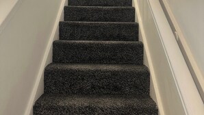 Una escalera con peldaños alfombrados que conduce a una plataforma.