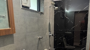 Baño con lavamanos, inodoro y zona de ducha.