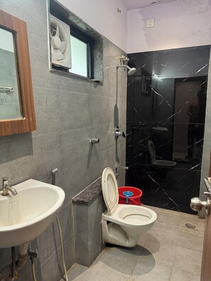 A bathroom with a sink, toilet, and shower area. - Hotel West24 (Nagpur)