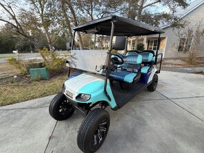 Ein Golfmobil steht auf einer Auffahrt.