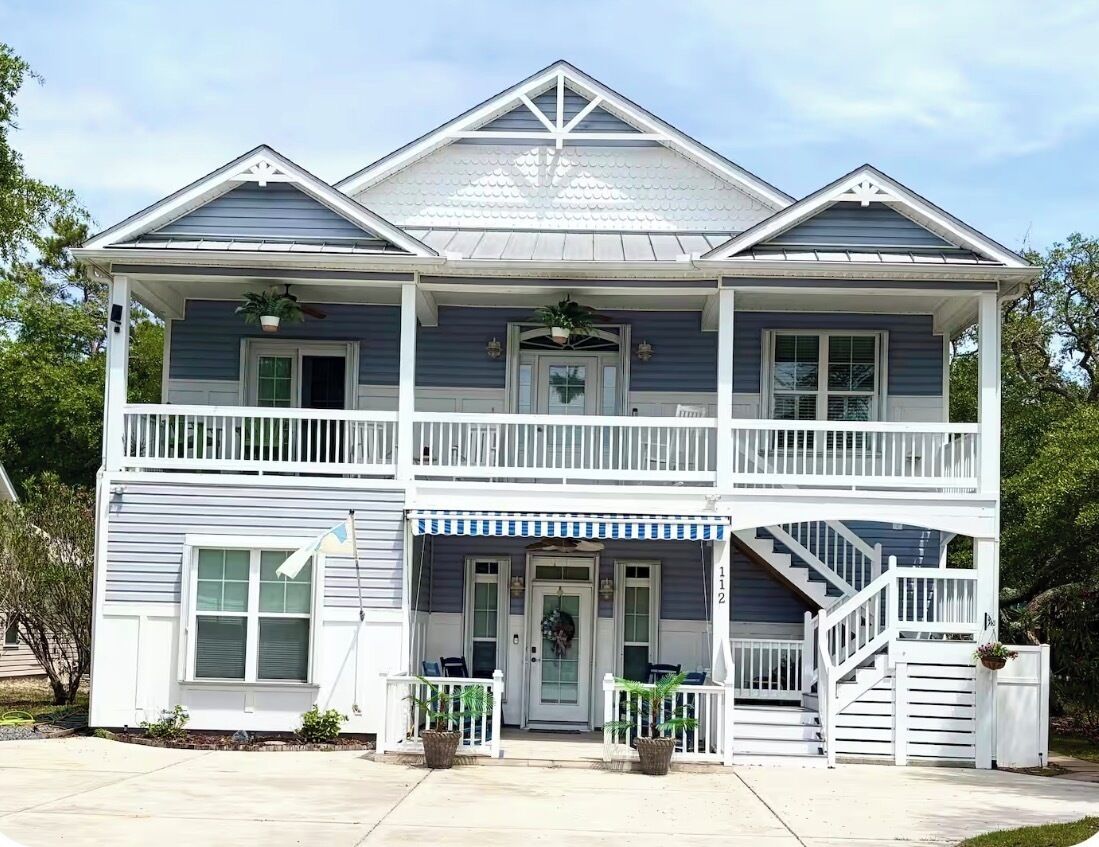 A two-story house with a front porch, a staircase, and a number '112' on the front.