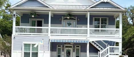A two-story house with a front porch, a staircase, and a number '112' on the front.