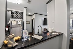 A modern kitchen with a refrigerator, a sink, and a countertop. - Tusk & Tide | Near the Stadium & Campus! (Tuscaloosa)