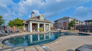 A swimming pool with lounge chairs and a covered patio area. - Welcome to Tusk & Tide! (Tuscaloosa)