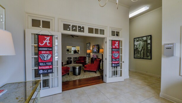 A spacious living room with a fireplace, a dining area, and a kitchen visible through an open door. - Welcome to Tusk & Tide! (Tuscaloosa)