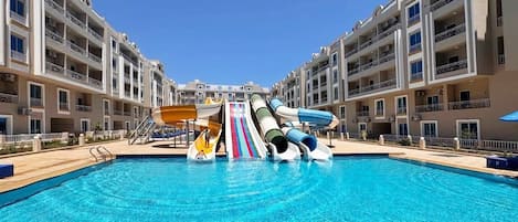 Piscina con tobogán y zona de juegos infantiles.