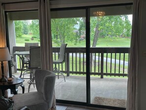 A room with a sliding glass door leading to a covered outdoor area with a table and chairs. - Golf Front 4 Bedroom (Branson)