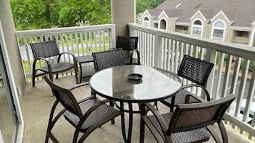 A covered outdoor patio with a round table and six chairs.