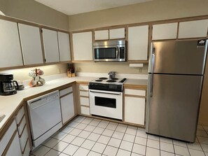 Une cuisine équipée d’un lave-vaisselle, d’une cuisinière, d’un four à micro-ondes et d’un réfrigérateur.
