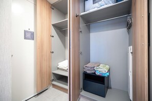 A walk-in closet with wooden doors, a metal handle, and a towel rack. - 501 First | StayChic Miami | Rooftop Pool & More (Miami)