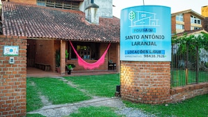 A building with a tiled roof, a brick facade, and a sign indicating it is a pousada named 'Santo António Laranjal.' - pousada santo antonio (Pelotas)