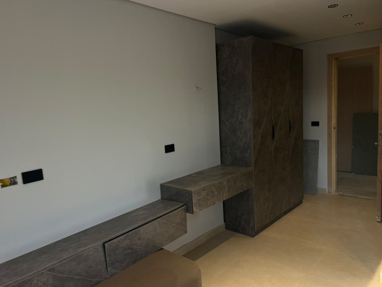 A modern interior with a built-in bench and a dark accent wall.
