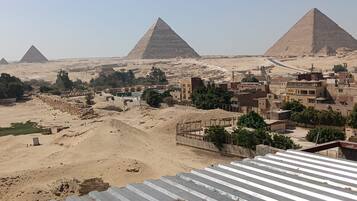 A view of the pyramids with a modern cityscape in the foreground.