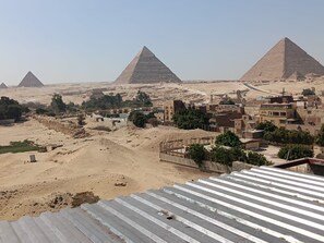 A view of the pyramids with a modern cityscape in the foreground. - Royal Pyramids Land Hotel (Giza)