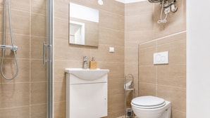 Un baño moderno con ducha, inodoro y lavamanos.
