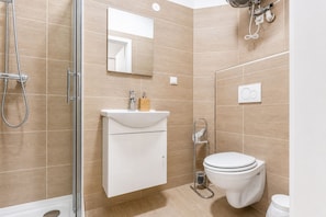 A modern bathroom with a shower, toilet, and sink.