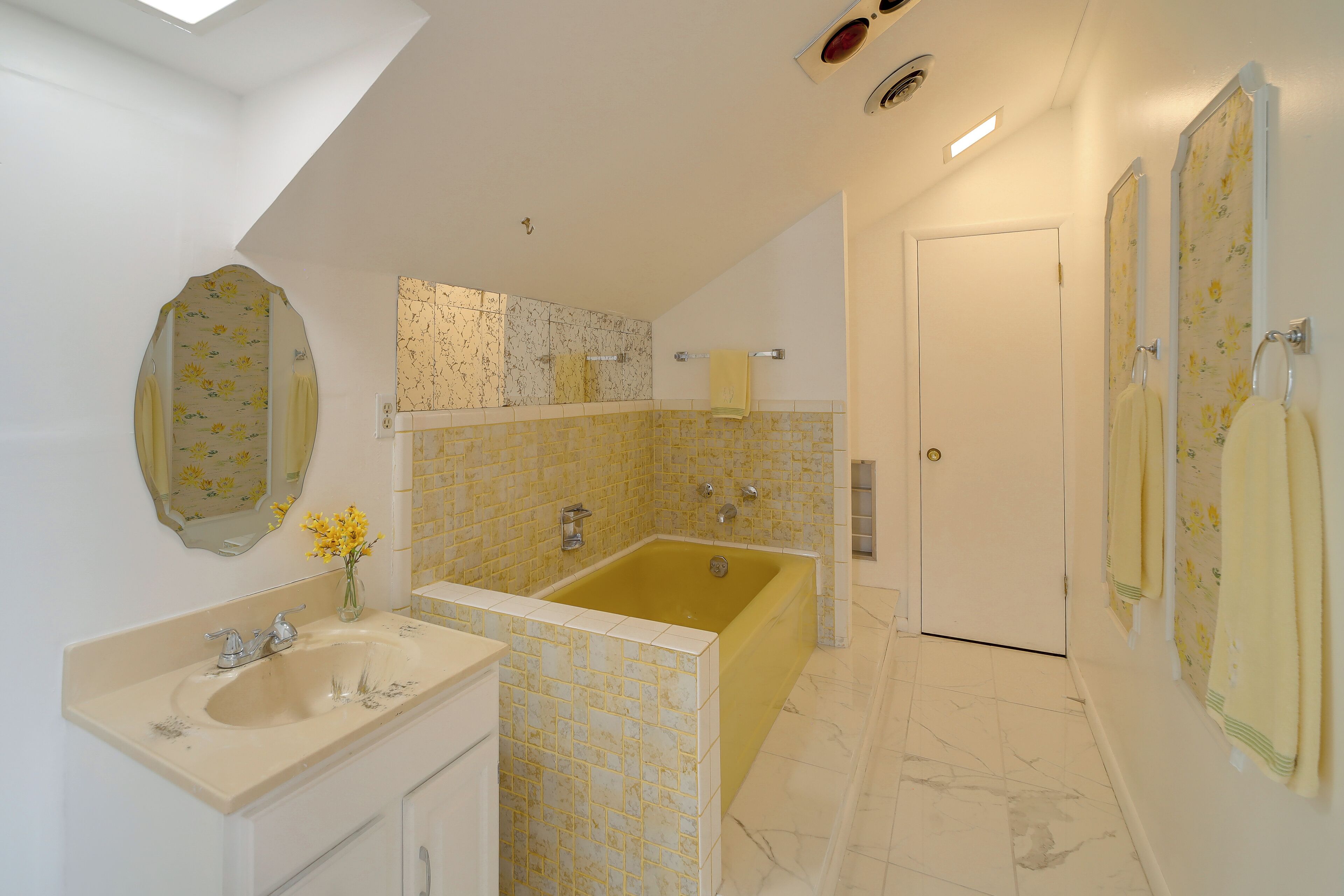 Une salle de bain avec une baignoire, un lavabo et un miroir.