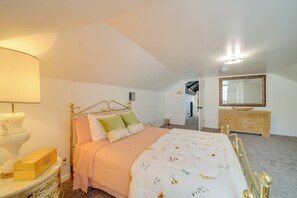 Un dormitorio con cama, cómoda, espejo y lámpara.