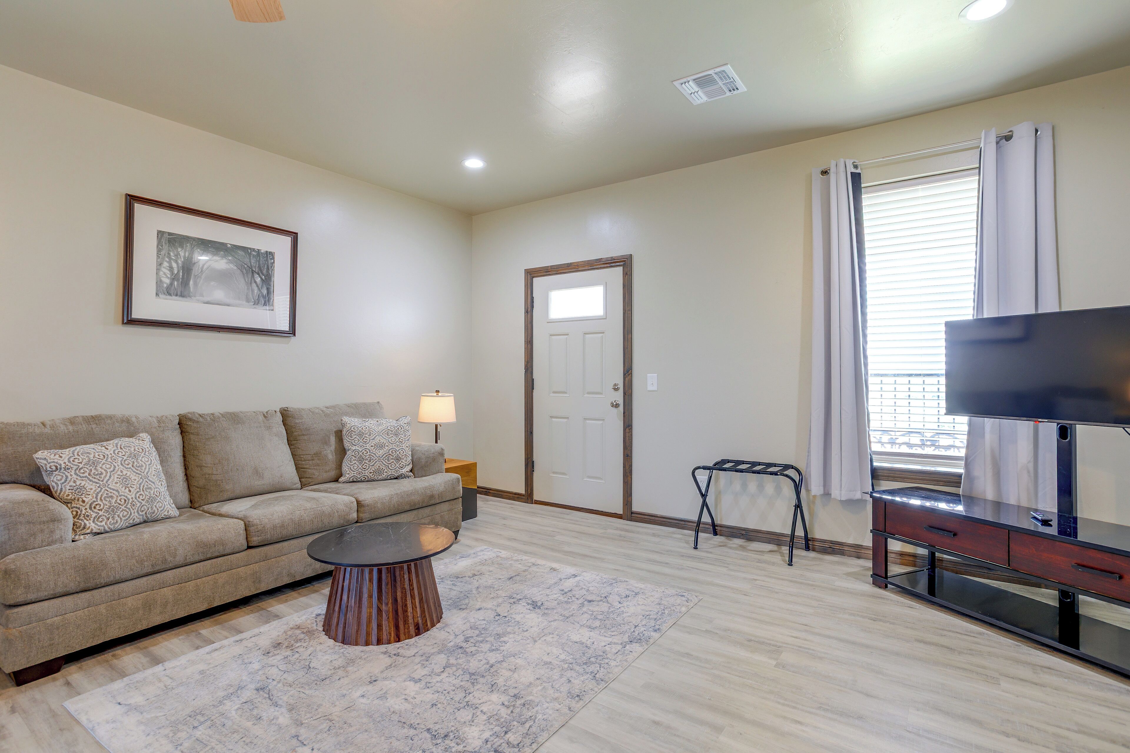 A living room with a sofa, a coffee table, a TV, and a door.
