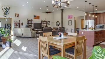 A spacious living area with a dining table, chairs, a sofa, and a television.