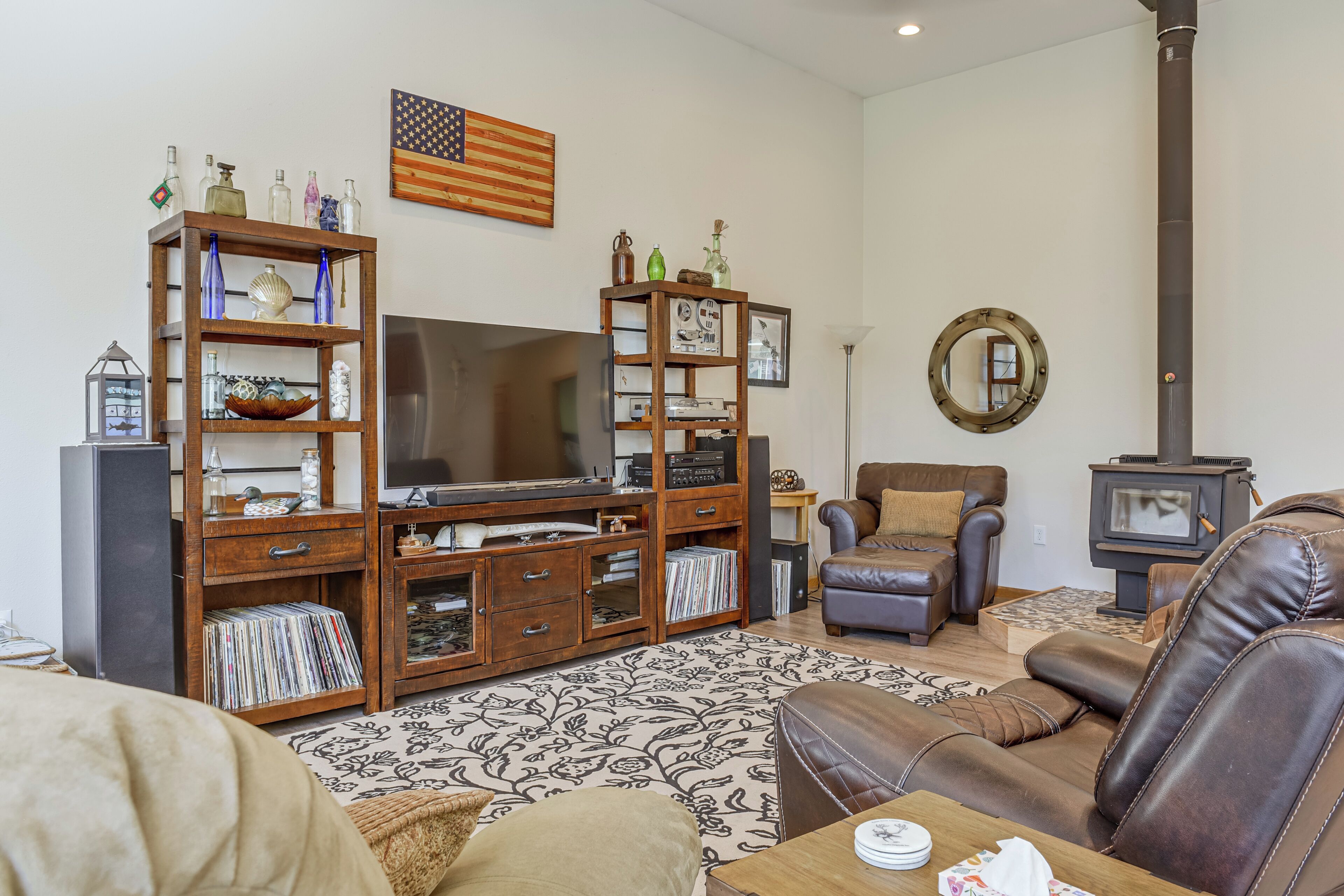 A living room with a wooden entertainment center, a television, a fireplace, and a comfortable seating area.