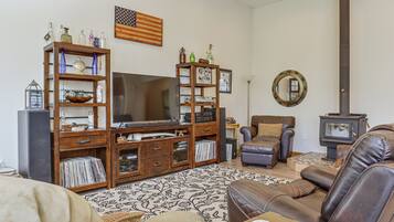 A living room with a wooden entertainment center, a television, a fireplace, and a comfortable seating area.