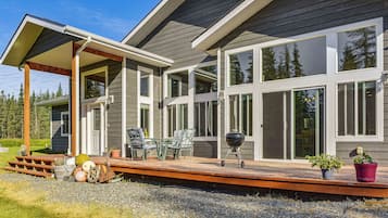 A modern house with a covered patio, large windows, and a deck.